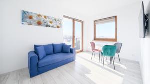 salon z niebieską kanapą i stołem w obiekcie Apartamenty Sun & Snow BLUE II w Sarbinowie