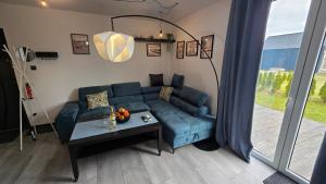a living room with a blue couch and a table at Baltic Barns Bura in Wytowno