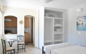 a room with a table and a bed and a kitchen at Majestic Blue in Mandrakia