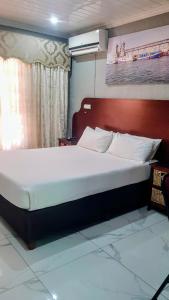 a large bed with a red headboard in a bedroom at Rainbow Guest House and Tours in Uitenhage