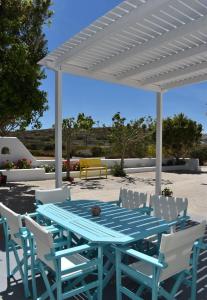 a blue table and chairs under a white pergola at Majestic Blue in Mandrakia