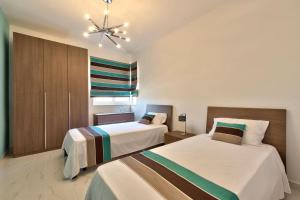 a bedroom with two beds and a chandelier at Apartment with Private Jacuzzi and Terrace in St Julians 3 Bedrooms in St. Julianʼs