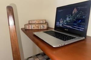 a laptop computer sitting on top of a wooden desk at LN Flats & Suites in Uberlândia