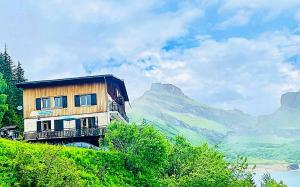a house on the side of a hill with a mountain at Chalet de Roselend in Beaufort