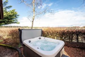 a bath tub sitting in a yard next to a field at Redlands Country Lodge Apartments with Hot Tubs in Ladybank