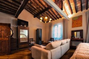a living room with a couch and a television at IL PALAZZO DEL CARDINALE in Montalcino