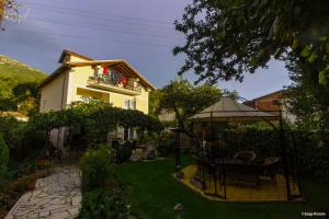 einen Garten mit Pavillon und ein Haus in der Unterkunft Pension Lale in Peštani