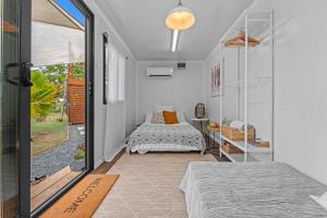 Un dormitorio con dos camas y una puerta corrediza de cristal. en Green Cottage #1 Pitahaya, en Cabo Rojo