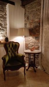 a green chair sitting next to a table with a lamp at Il Vicolo agli Orti - Centro storico - Lake Como in Bellano