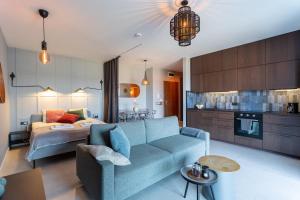 a living room with a blue couch and a bed at Warsaw Concierge Lake Pool Gym in Zegrze Południowe