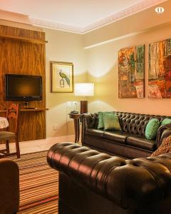 a living room with a couch and a television at Hotel OT in Três Lagoas