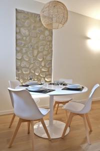 a white dining room with a white table and chairs at Concordia12 in Calmasino