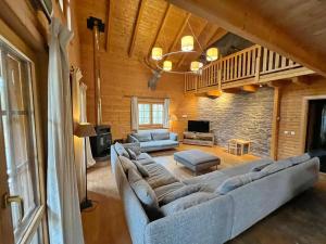 a living room with a large couch and a tv at La Grande Ourse in Durbuy