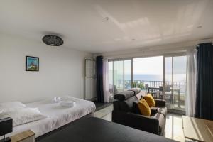ラ・ボールにあるStudio face merのベッドとソファとバルコニーのある寝室
