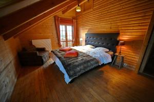 ein Schlafzimmer mit einem großen Bett in einer Holzhütte in der Unterkunft La Grande Ourse in Durbuy