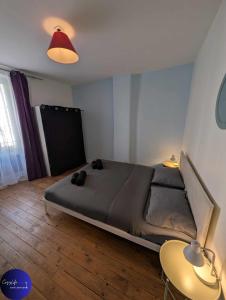 a bedroom with a bed and two tables and a lamp at Le Jardin d'Angély by CozyLife Central Jardin in Niort