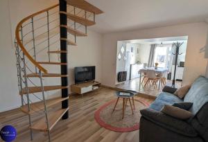 a living room with a spiral staircase and a living room at Le Jardin d'Angély by CozyLife Central Jardin in Niort
