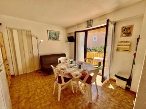 ein Esszimmer mit einem Tisch und Stühlen in einem Raum in der Unterkunft Appartement T2 climatisé à Cavalaire, parking privé, proche centre et plages, balcon au calme - FR-1-226B-110 in Cavalaire-sur-Mer