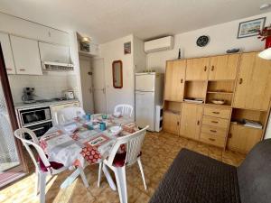 eine Küche mit Tisch und Stühlen in einem Zimmer in der Unterkunft Appartement T2 climatisé à Cavalaire, parking privé, proche centre et plages, balcon au calme - FR-1-226B-110 in Cavalaire-sur-Mer