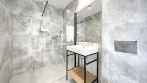 łazienka z umywalką i prysznicem w obiekcie Apartamenty Sun & Snow BLUE II w Sarbinowie