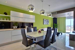 a kitchen and dining room with a table and chairs at Apartment with Private Jacuzzi and Terrace in St Julians 3 Bedrooms in St. Julianʼs
