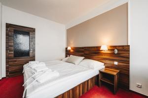 sypialnia z dużym łóżkiem z drewnianym zagłówkiem w obiekcie Hotel Palcát w Taborze