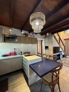 eine große Küche mit Tisch und Kronleuchter in der Unterkunft Reserva BG - Apto Praiano - Vista mar in Barra Grande