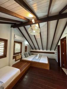 ein großes Zimmer mit zwei Betten und einem Kronleuchter in der Unterkunft Reserva BG - Apto Praiano - Vista mar in Barra Grande + 8 Fotos