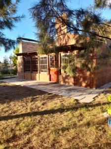 an old brick house with a tree in front of it at Cabaña Paralelo 1 in Viedma