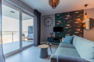 a living room with a couch and a clock on the wall at Warsaw Concierge Lake Pool Gym in Zegrze Południowe