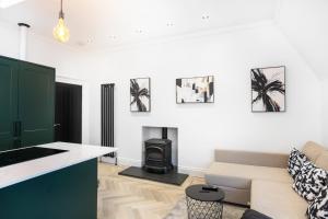 Una sala de estar con un sofá y una estufa. en Luxury Apartment - Portobello, en Edimburgo