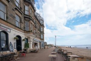 una calle con mesas y sillas en la playa en Luxury Apartment - Portobello, en Edimburgo