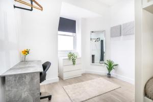 Habitación blanca con escritorio y espejo. en Luxury Apartment - Portobello, en Edimburgo