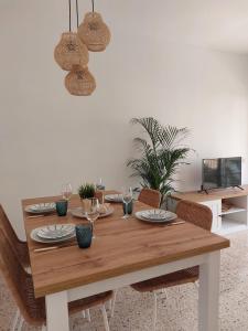 a dining room table with plates and glasses on it at Cozy beach apartment in Calafell