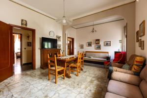 a living room with a table and chairs and a couch at Casa di via Manzoni by BarbarHouse in Casarano