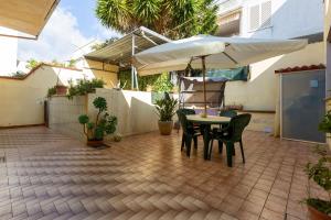 a patio with a table and an umbrella at Casa di via Manzoni by BarbarHouse in Casarano