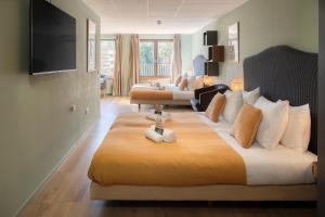 a bedroom with a large bed and a living room at Hotel de Korenwolf in Gulpen