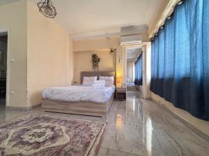 a bedroom with a large bed and a blue curtain at Champollion apartments in Cairo