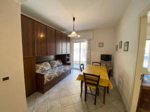 una sala de estar con una cama y una mesa en Bilocale Villa Marina a pochi passi dal mare di Ceriale, en Ceriale