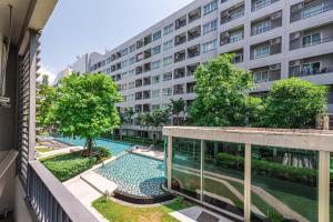 an apartment building with a swimming pool in front of a building at Elio Sukhumvit 64 in Bangkok