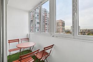 Una mesa y dos sillas en una habitación con ventanas. en Chic and spacious apart with parking, en Colombes 12 fotos más