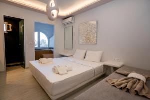 a bedroom with a large white bed with towels on it at Zen Suites & Spa in Perissa