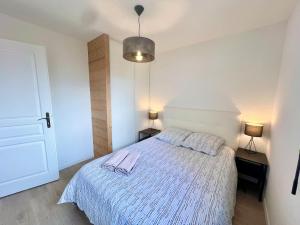Un dormitorio con una cama con una toalla morada. en Le Silène T3 - 4 personnes, en Cluses
