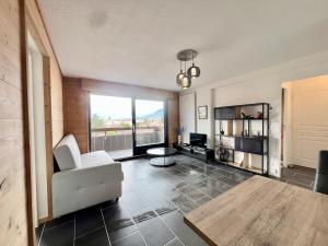 una sala de estar con un sofá y una mesa en Le Silène T3 - 4 personnes, en Cluses