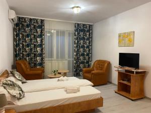 a hotel room with two beds and a television at Hotel Green House in Craiova