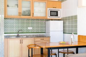 a kitchen with a table and a refrigerator at Plus Fariones Apartamentos in Puerto del Carmen