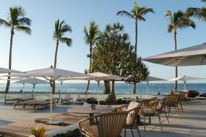 a restaurant with tables and umbrellas on the beach at Plus Fariones Suite Hotel in Puerto del Carmen