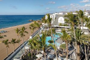 an aerial view of a resort with palm trees and the beach at Plus Fariones Suite Hotel in Puerto del Carmen