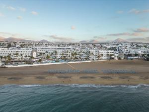 a view of a beach with buildings and the ocean at Plus Fariones Suite Hotel in Puerto del Carmen