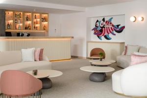 a living room with couches and tables and a counter at Plus Fariones Suite Hotel in Puerto del Carmen